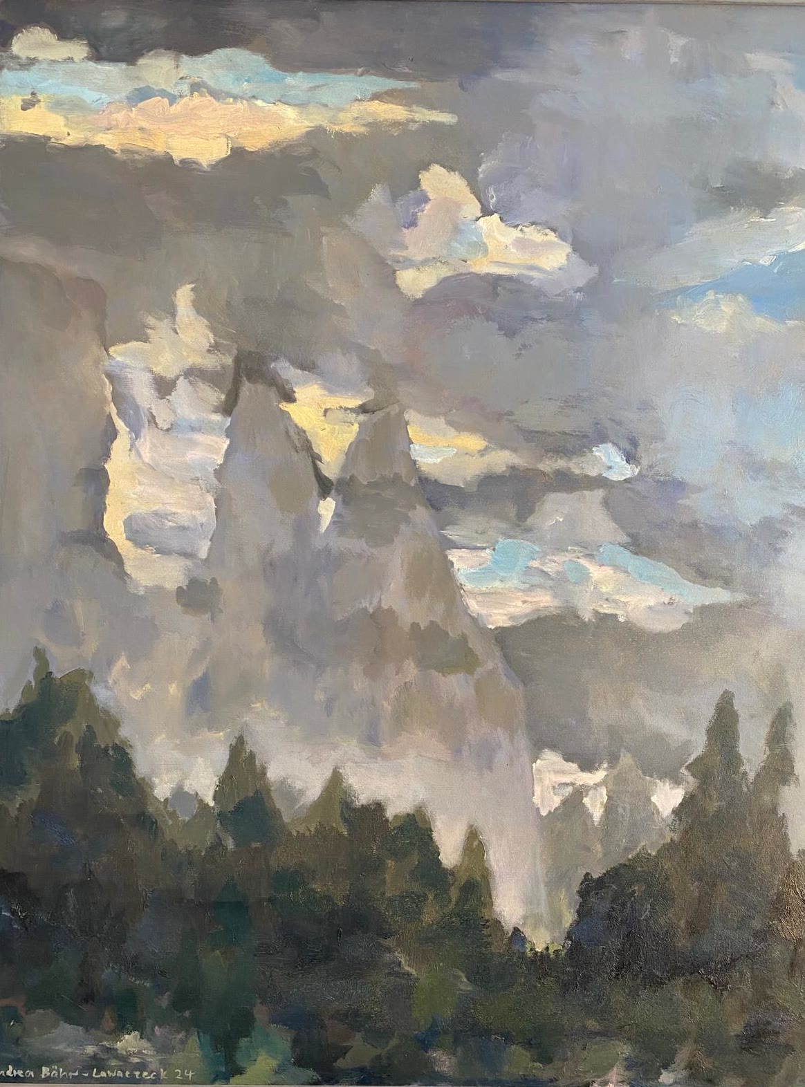 Wolkenschlieren ziehen über helle Felsgipfel, davor dunkle Nadelbäume